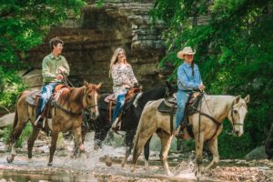 Couple Horseback Riding through Little Indian Creek