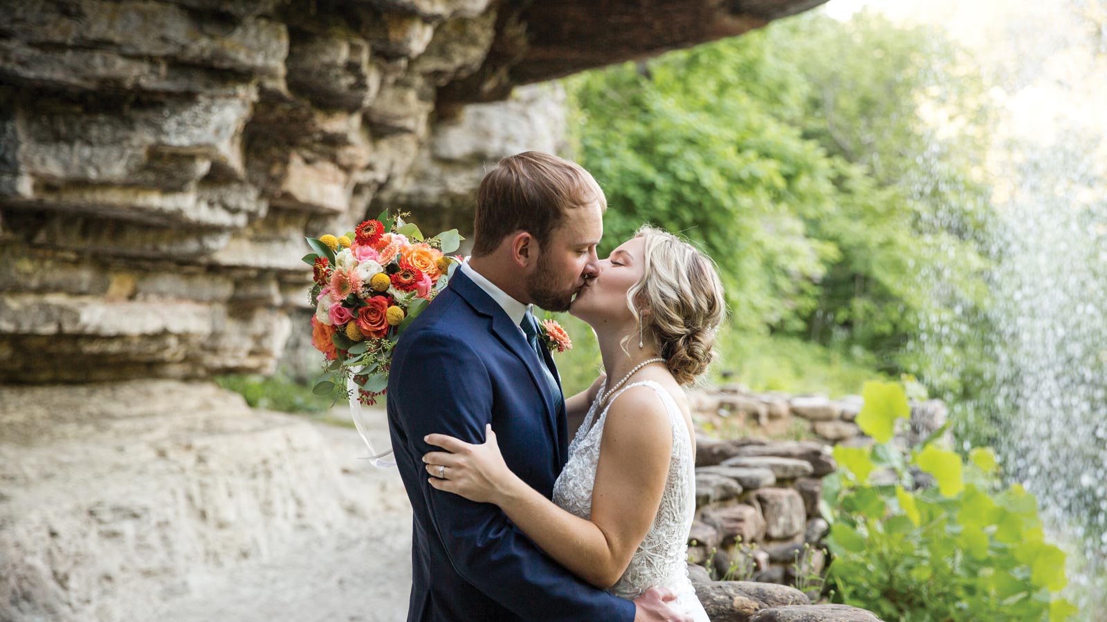 Couple kissing under a waterfall